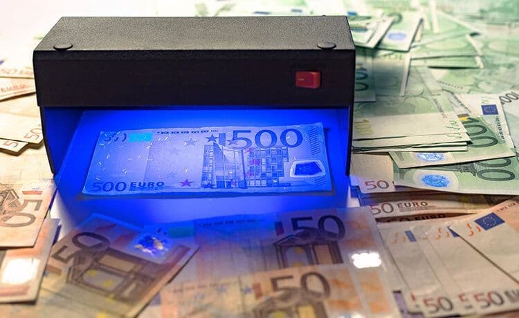 500-Euro-Geldschein liegt unter einer UV-Lampe um Echtheit zu prüfen.