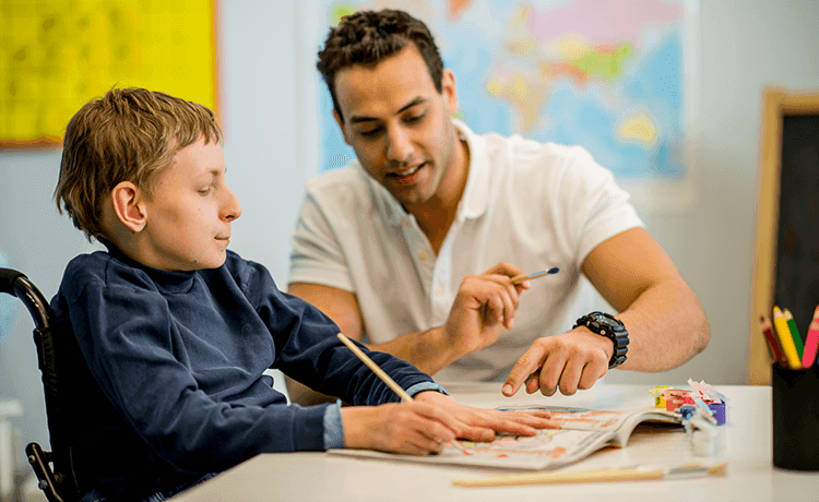 Schulbegleiter im Unterricht mit Kind