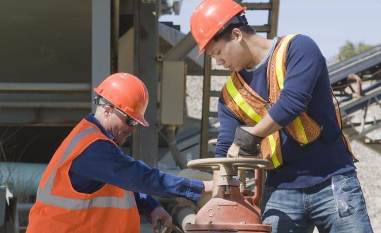 Zwei Bauarbeiter arbeiten auf einer Baustelle.
