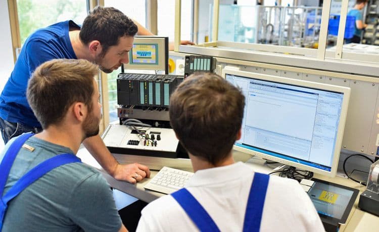 Drei junge Männer bei der Arbeit als Elektroanlagenmonteur.