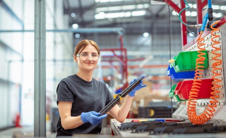 Eine junge Verfahrensmechanikerin für Kunststoff- und Kautschuktechnik bei der Arbeit.