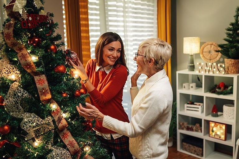 Enkelin schmückt mit ihrer Oma den Baum