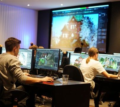 Studenten sitzen in einem Klassenraum vor dem Computer.