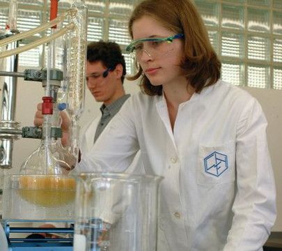 Junge Frau hat im Labor ein Reagenzglas in der Hand.