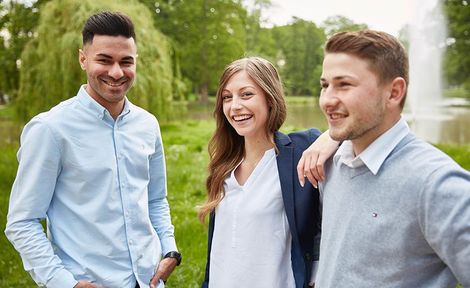 Drei junge Menschen lachen in die Kamera.