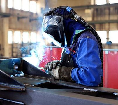 Ein Metalltechniker schweißt ein Stück Metall.