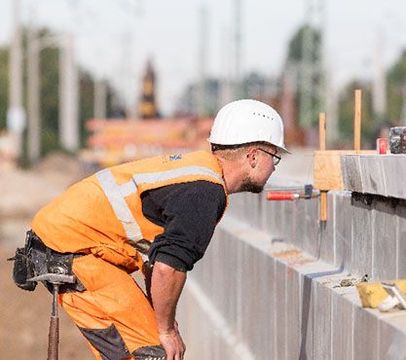 Stahlbetonbauer in Arbeitskleidung und Helm auf der Arbeit.