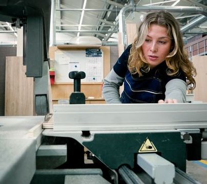 Junge Frau baut etwas an einem Caravan.