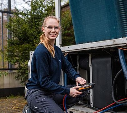 Junge Frau arbeitet an einem Kasten mit Kabel.