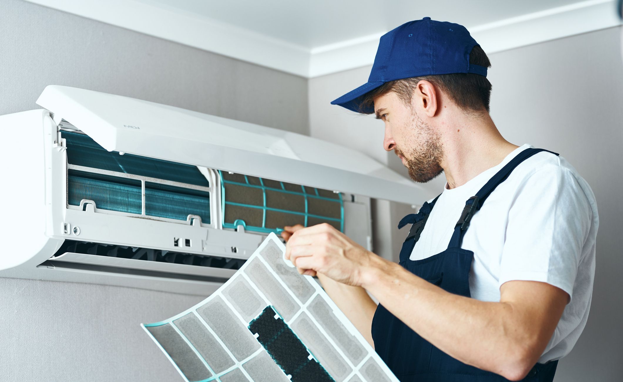 Junger Mann arbeitet an einer Klimaanlage.