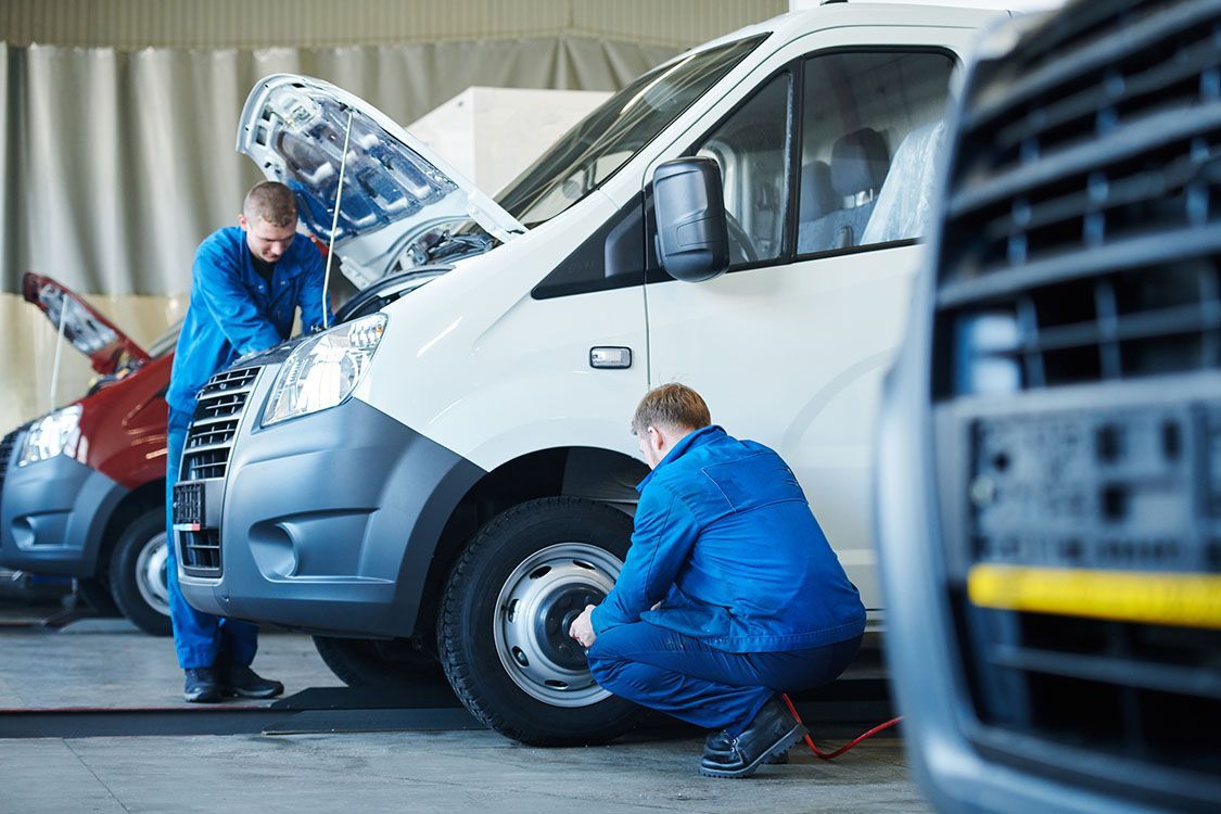 Zwei Karosserie- und Fahrzeugbaumechaniker arbeiten an einem Van