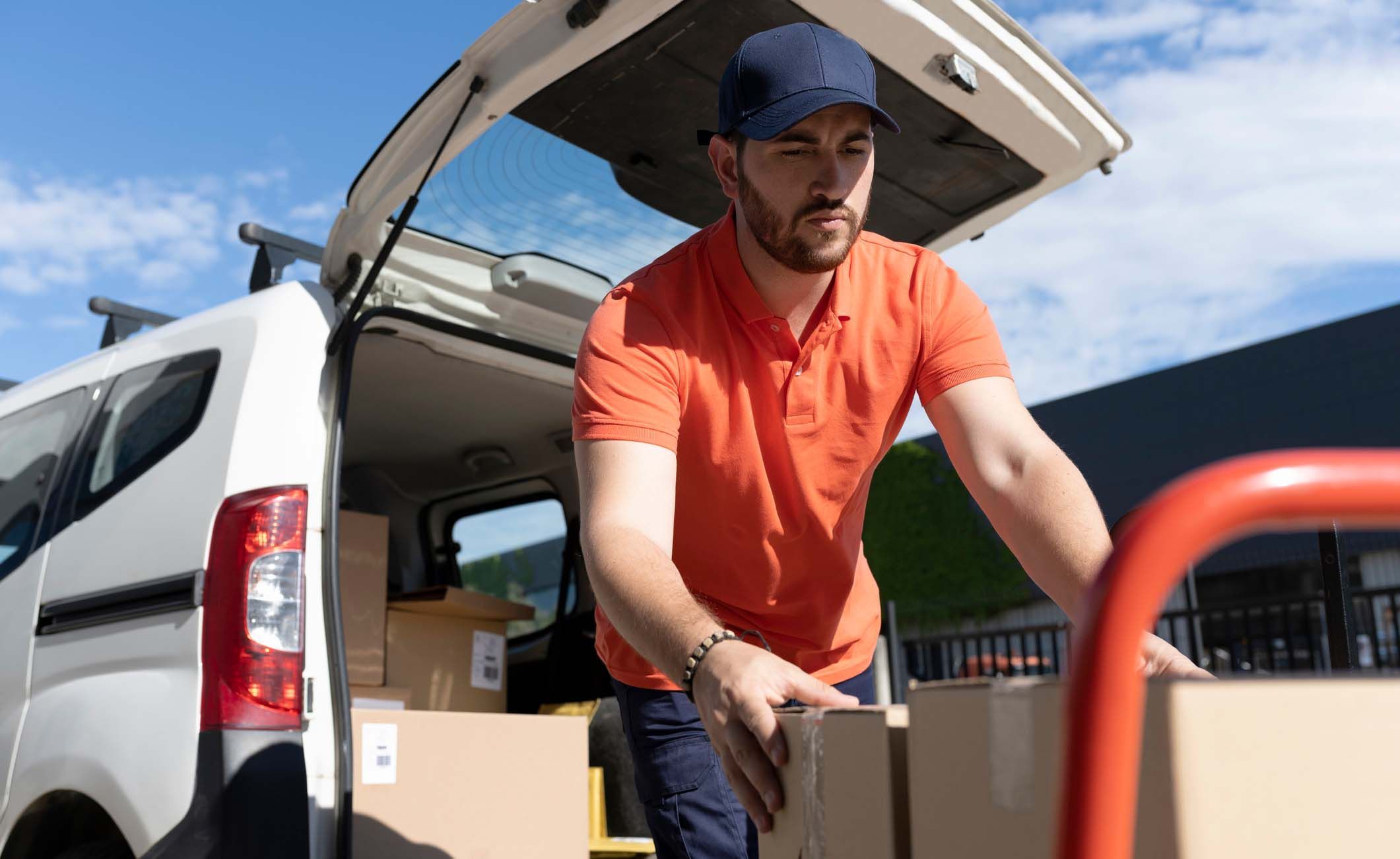Paketbote lädt Pakete ins Auto Paketbote lädt Pakete ins Auto