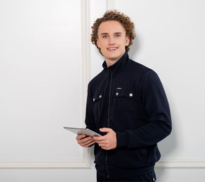 Junger Mann mit Laptop in der Hand schaut in die Kamera. Junger Mann mit Laptop in der Hand schaut in die Kamera.