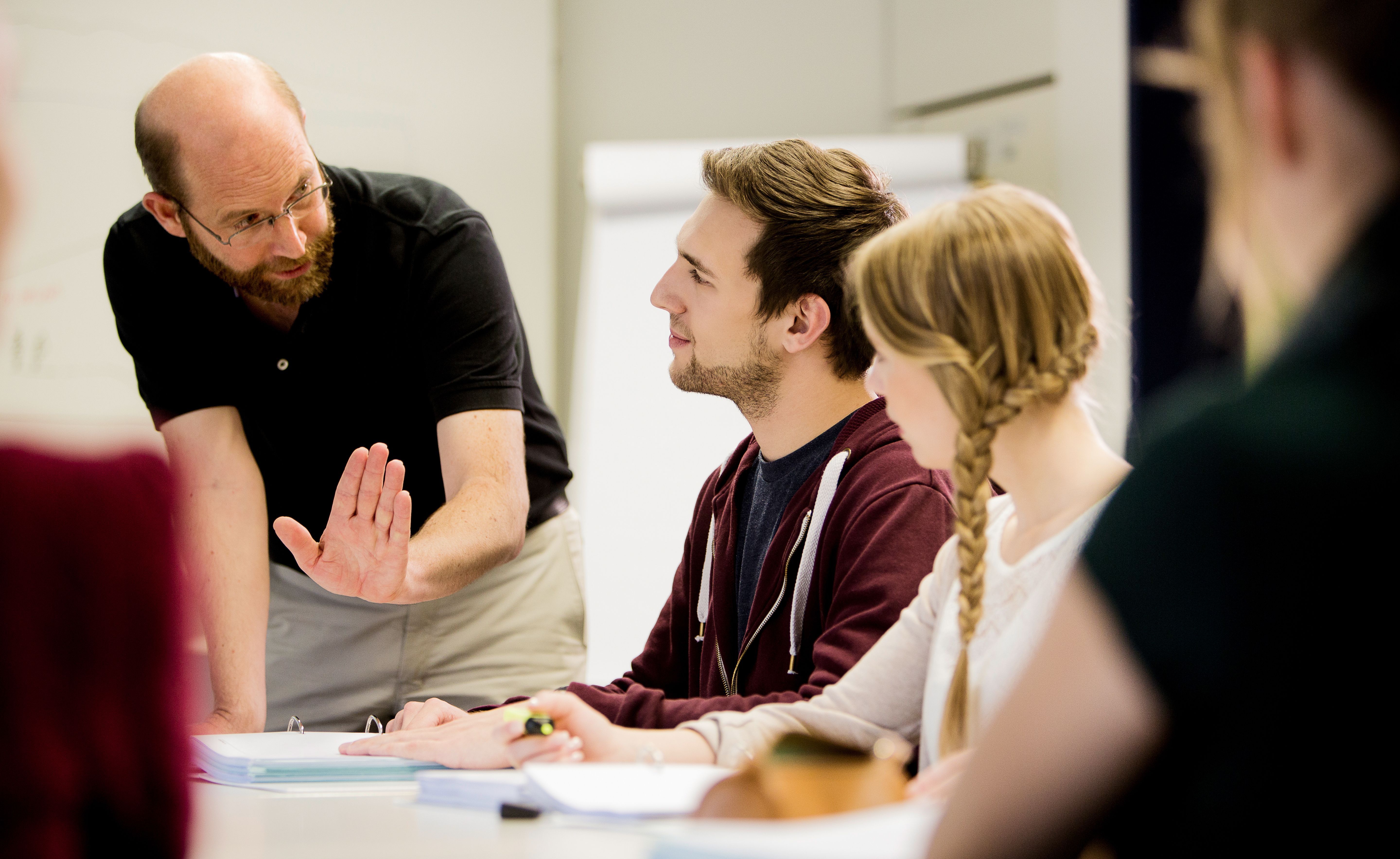 Lehrer erklärt Informatikstudenten den Lernstoff im Unterricht.