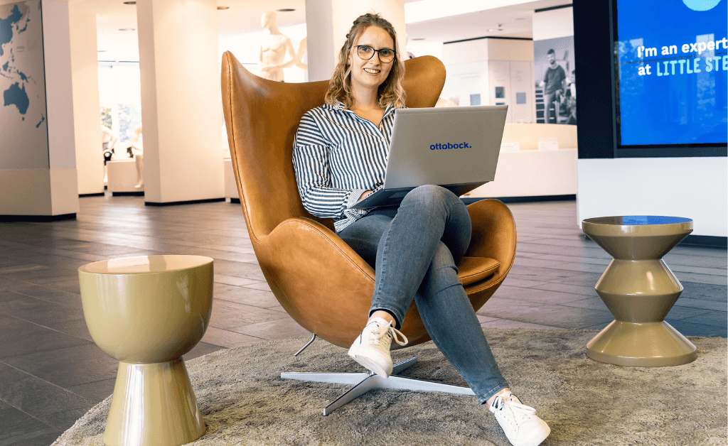 Eine Business Administration Studentin sitzt im Sessel und arbeitet.