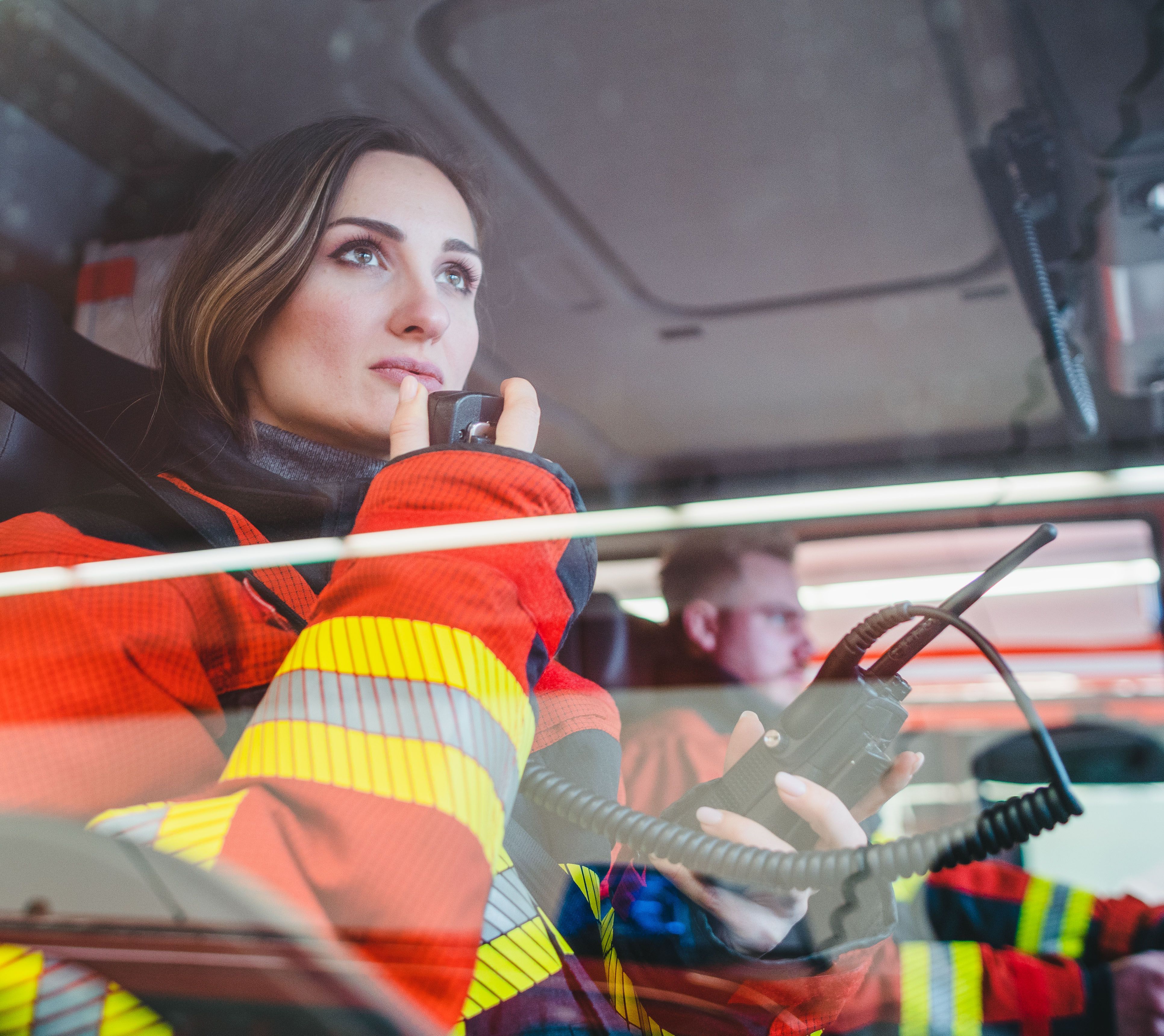 Feuerwehrfrau im Auto gibt einen Funkspruch durch.