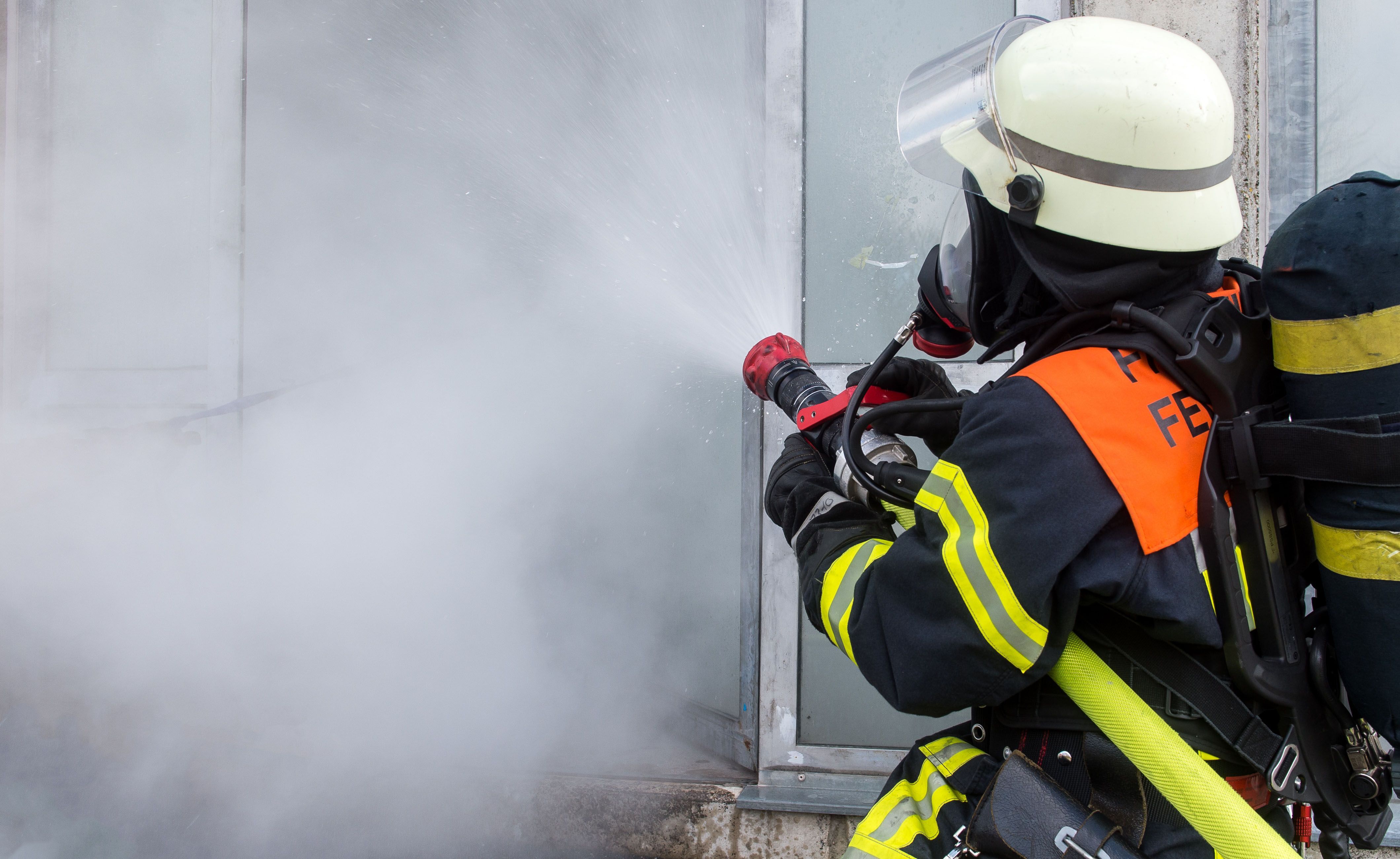 Ein Feuerwehrmann löscht ein Feuer.