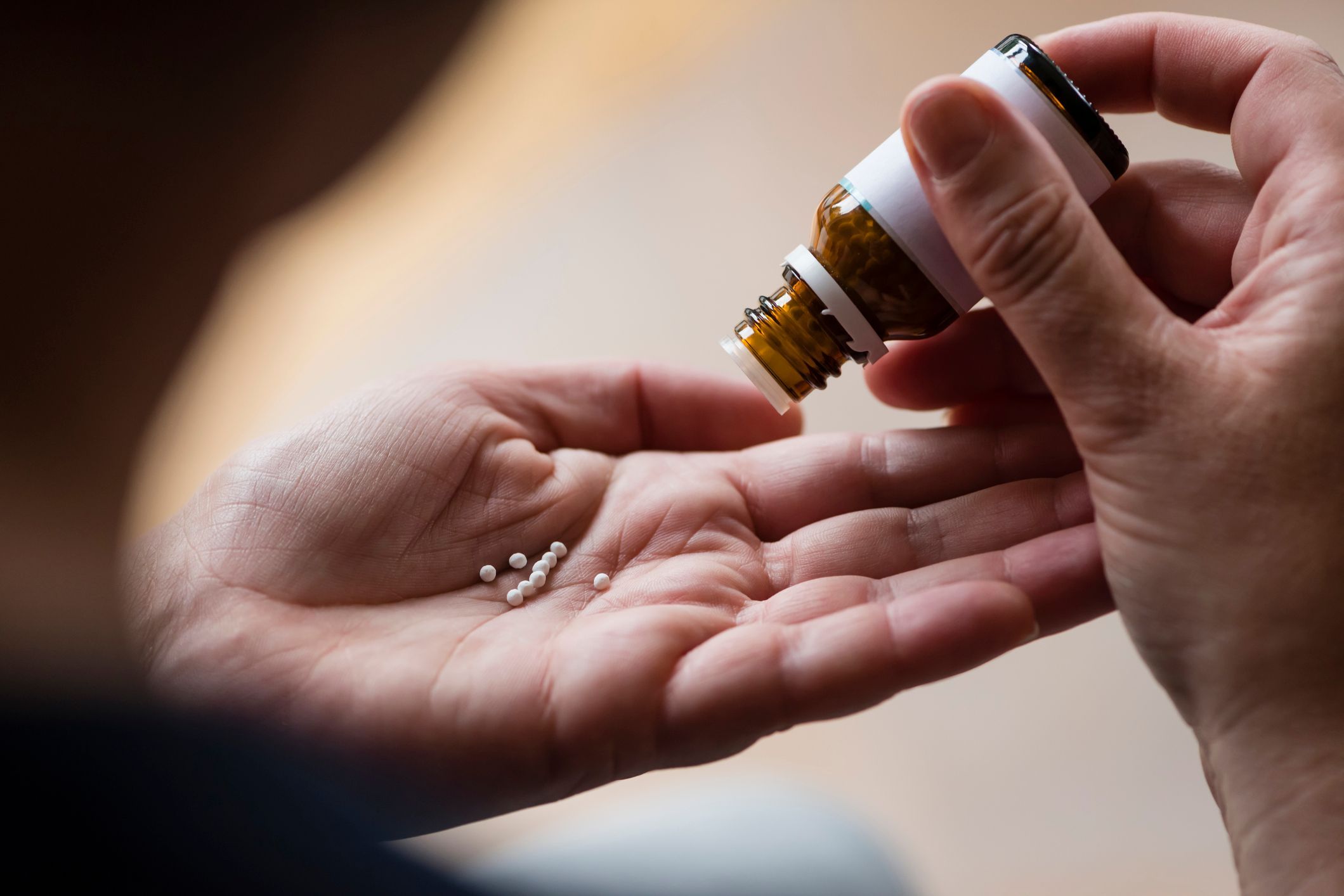 Eine Person nimmt homöopathische Mittel ein. Eine Person nimmt homöopathische Mittel ein.