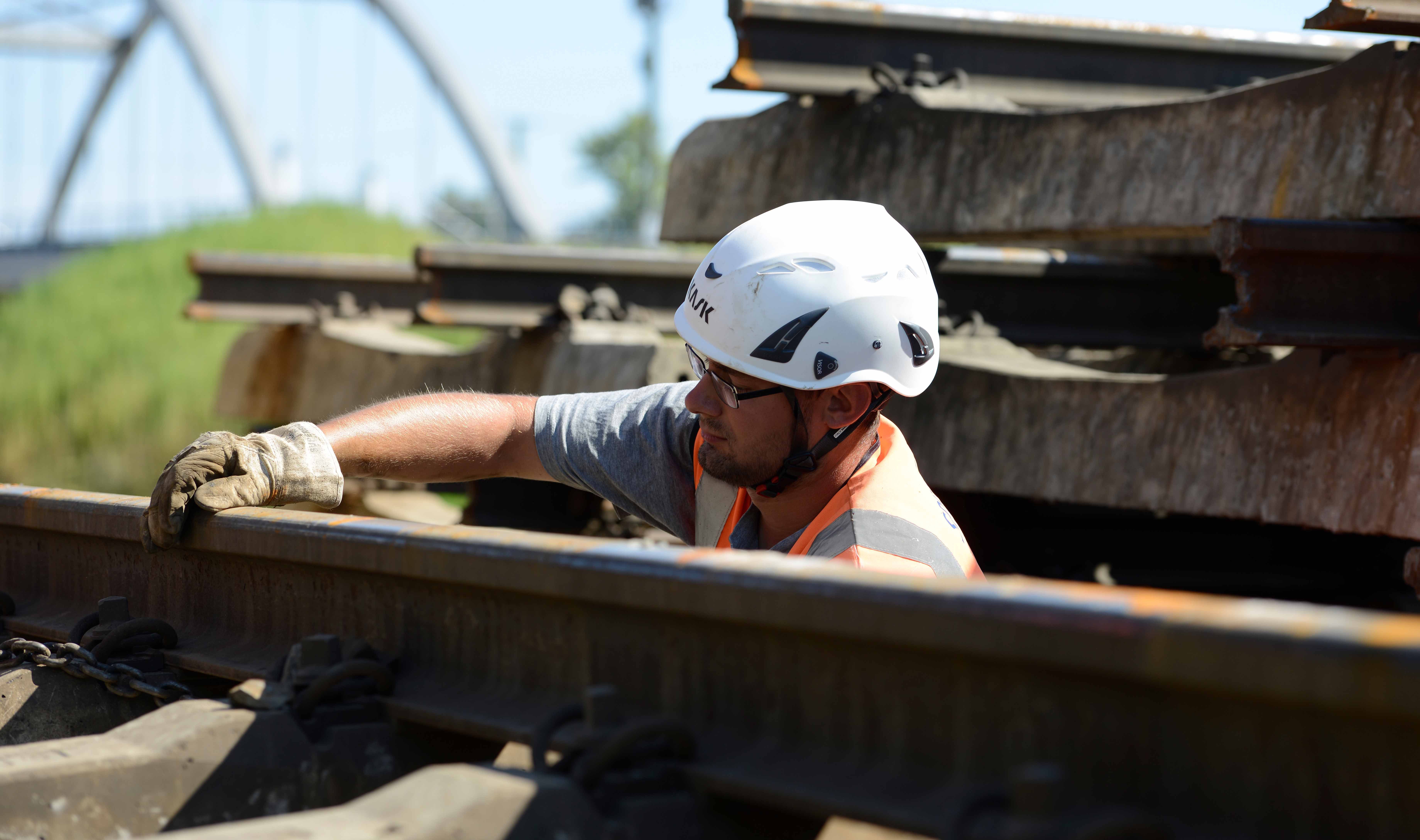 Gleisbauer mit Schutzhelm arbeitet an einer Weiche. Gleisbauer mit Schutzhelm arbeitet an einer Weiche.