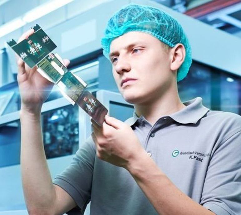 Ein Azubi guckt sich ein Produkt aus Pappe an. Ein Azubi guckt sich ein Produkt aus Pappe an.