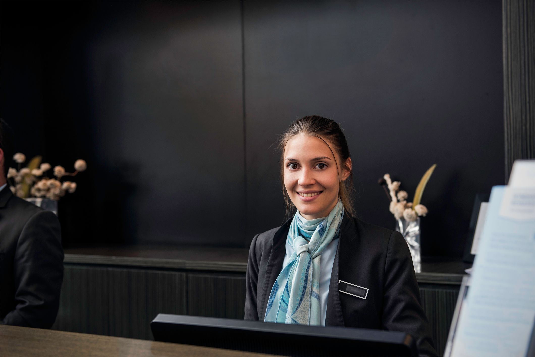 Hotelfachfrau-Auszubildende am Empfang eines Hotels Hotelfachfrau-Auszubildende am Empfang eines Hotels
