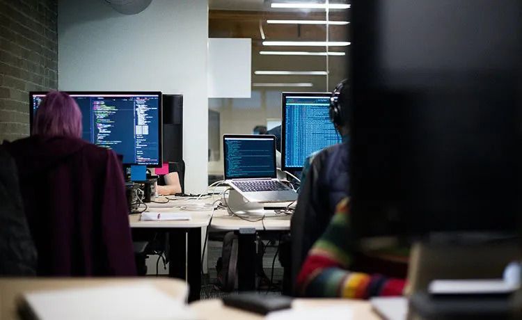 Infromationselektronikerinnen in der Ausbildung vor dem PC.