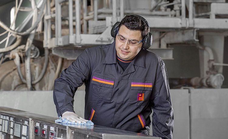 Gebäudereiniger bei Piepenbrock reinigt eine Maschine mit einem Lappen