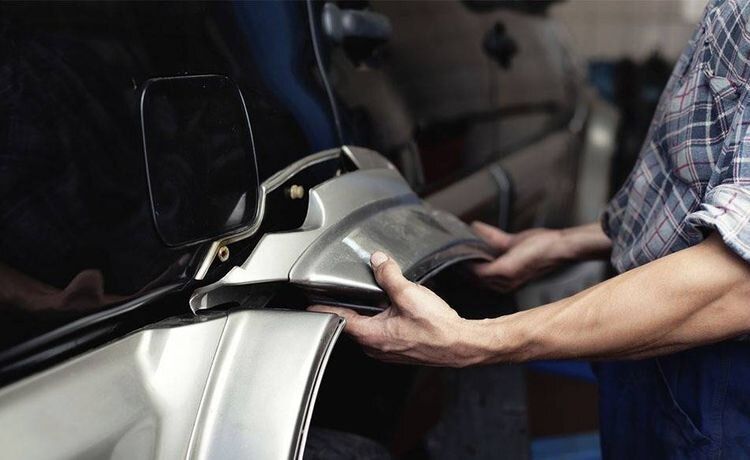 Karosserie- und Fahrzeugbaumechaniker arbeitet am Auto