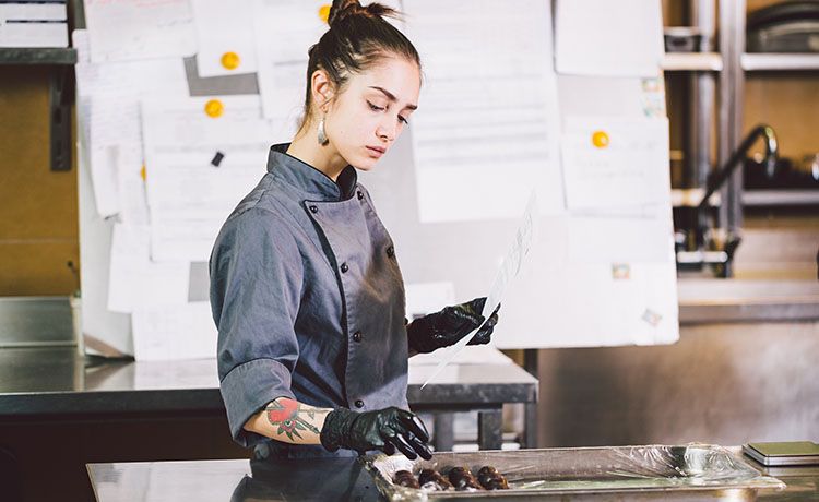 Junge Konditorin bei der Arbeit.