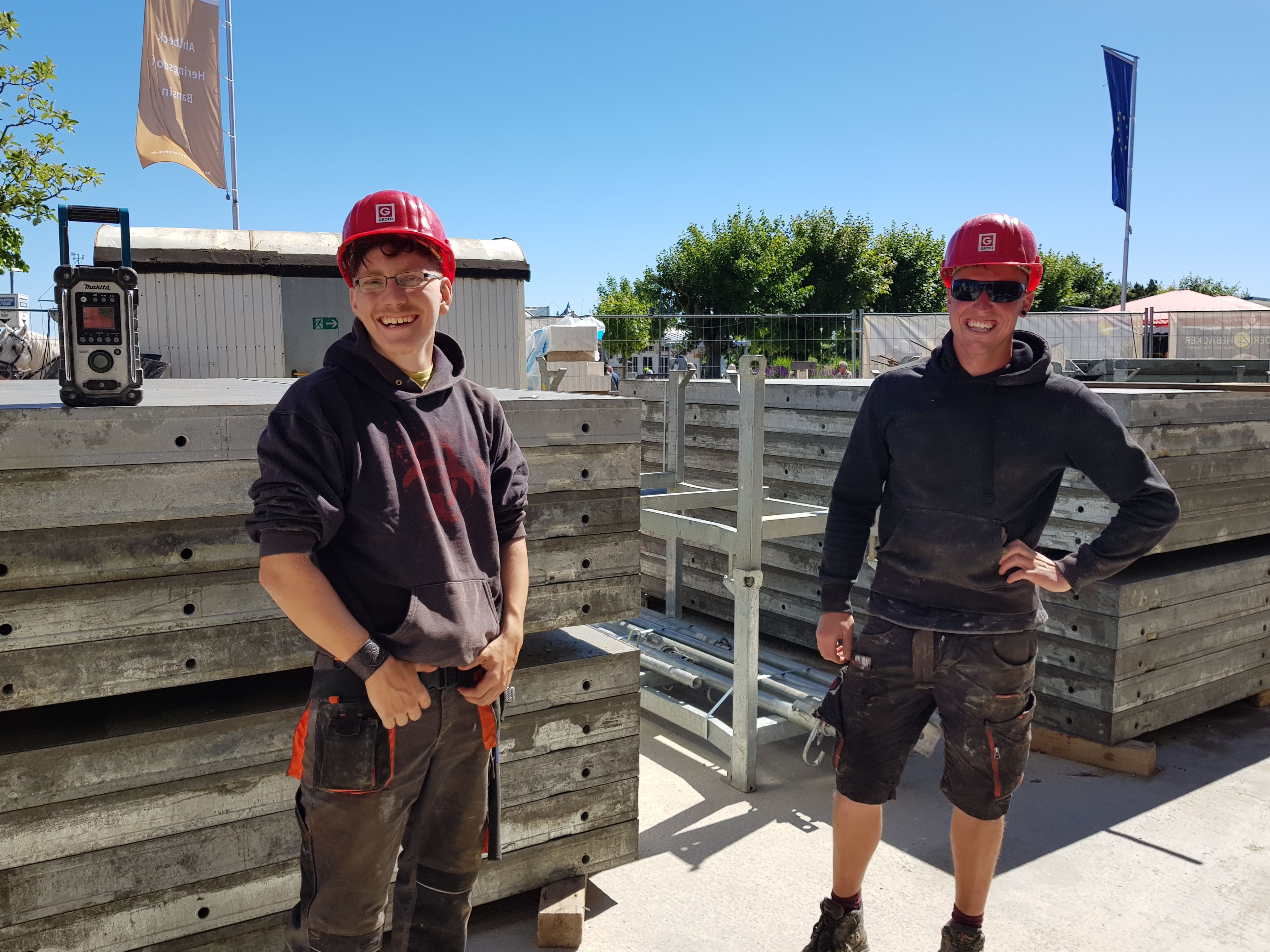 Junge Maurerazubis auf einer Baustelle mit Schutzhelm