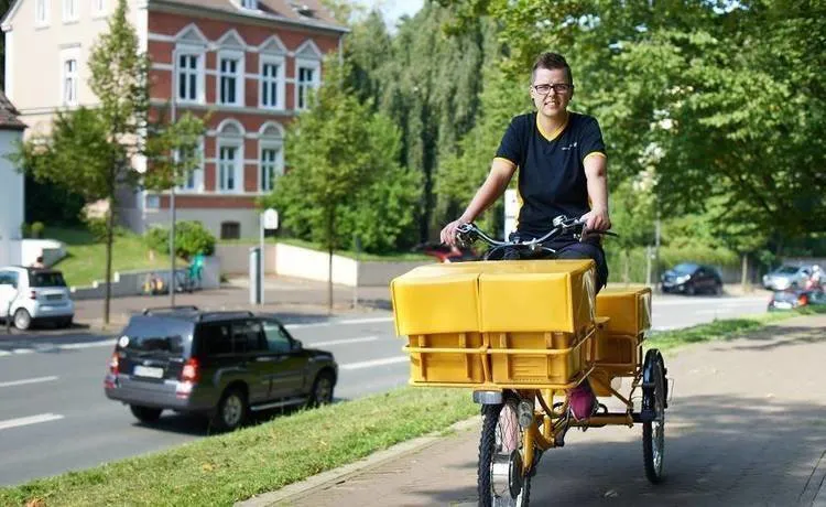 Postbote bei DHL auf dem Fahrrad