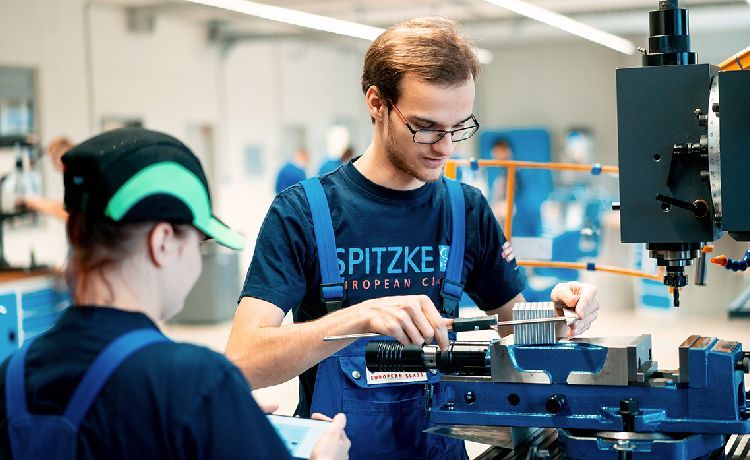 Azubi arbeitet an einem Gerät in einer Werkstatt.