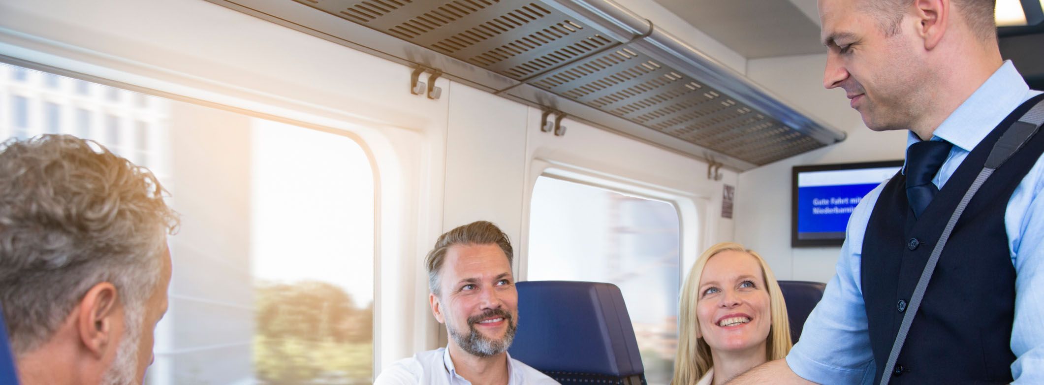 Zugbegleiter bei der Arbeit mit Fahrgästen