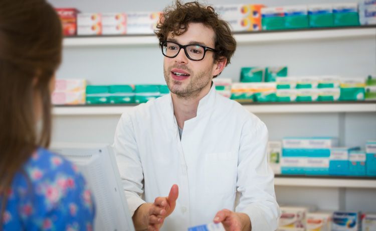 Junger Apotheker berät Kundin.