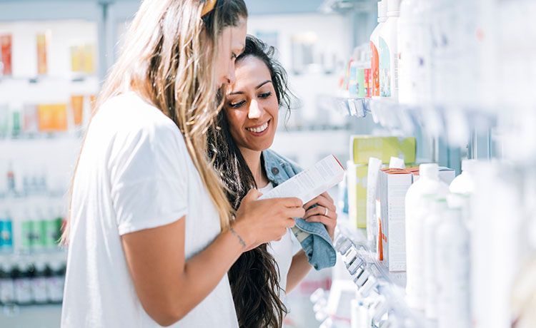 Verkäuferin zeigt einer Kundin ein Produkt.  Verkäuferin zeigt einer Kundin ein Produkt.