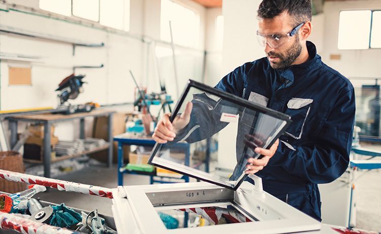 Ein Mann bearbeitet eine Glasscheibe.