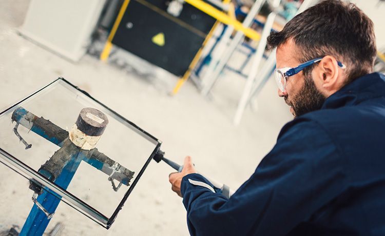 Ein Mann arbeitet an einer Glasscheibe. 