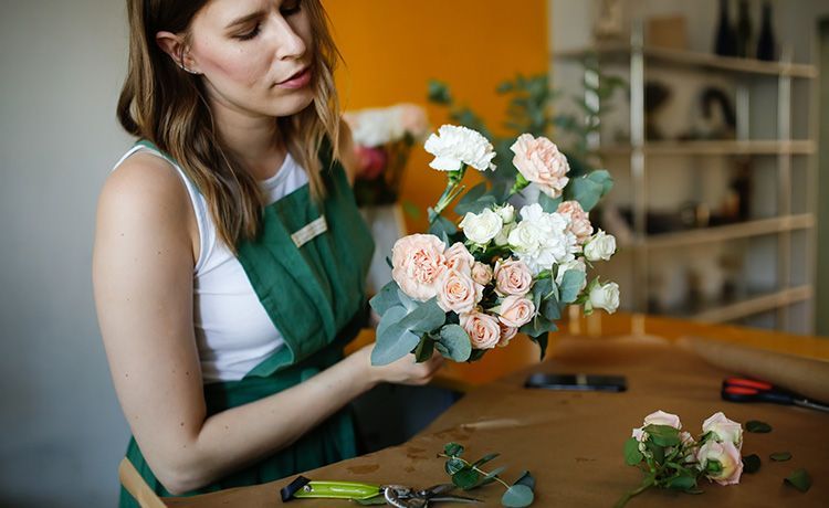 Junge Frau bindet einen Blumenstrauß.
