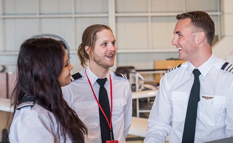 Zwei Azubis reden mit einem Piloten.