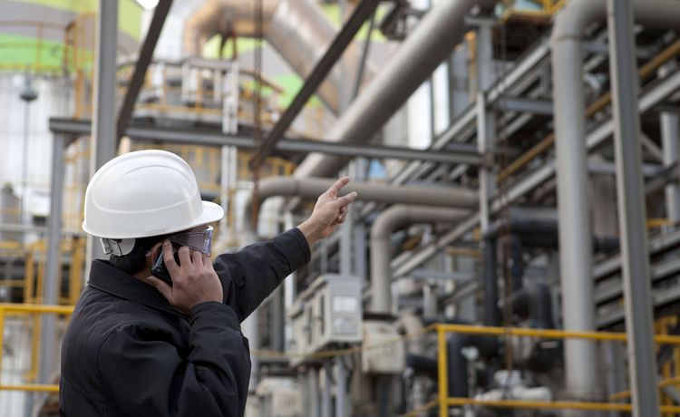 Bauarbeiter telefoniert in einer Halle. Bauarbeiter telefoniert in einer Halle.