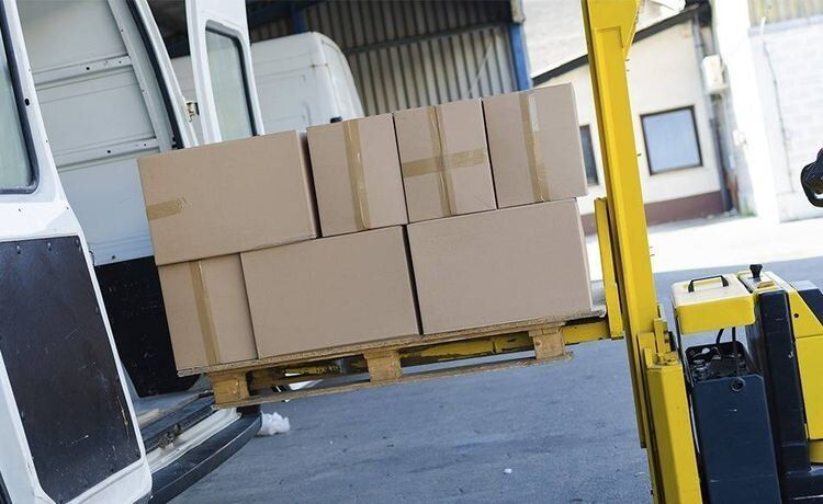 Kartons werden in einen Transporter verladen.