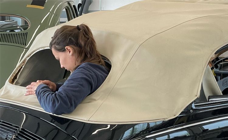 Eine Autosattlerin verkleidet den Außenbereich eines VW Beetles Eine Autosattlerin verkleidet den Außenbereich eines VW Beetles