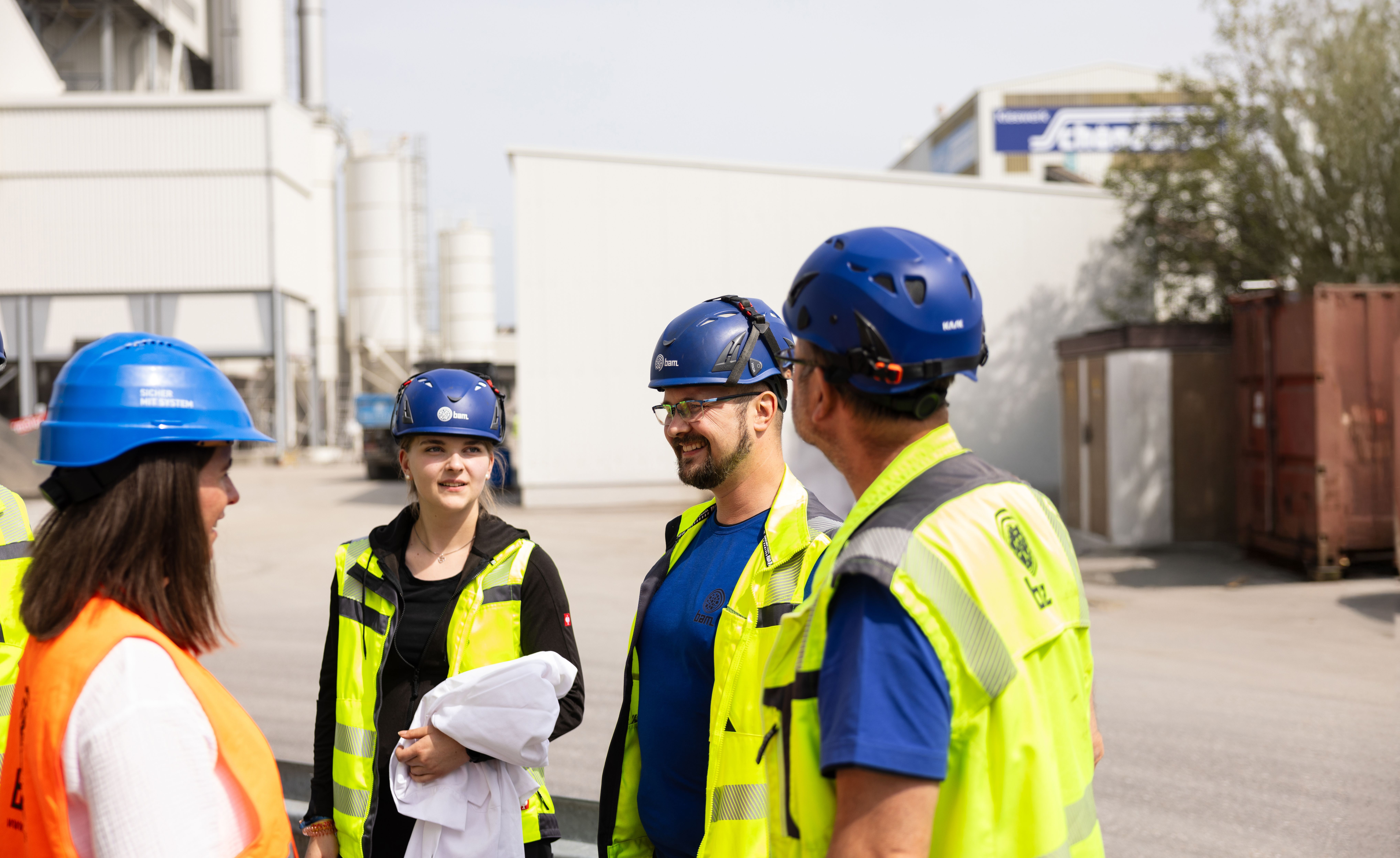 Verfahrensmechanikerinnen in der Steine- und Erdenindustrie unterhalten sich in Arbeitskleidung. Verfahrensmechanikerinnen in der Steine- und Erdenindustrie unterhalten sich in Arbeitskleidung.