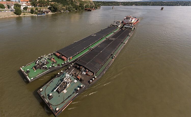 Schubboot fährt auf einem Fluss.