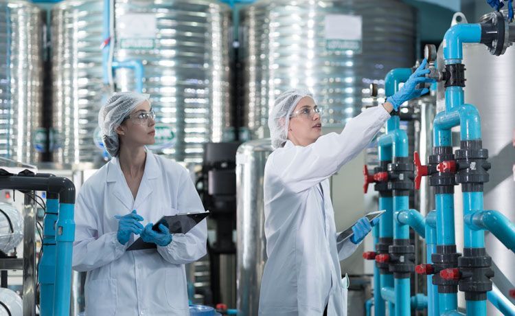 Zwei Chemikantinnen überprüfen die Produktion in einem Chemiewerk.