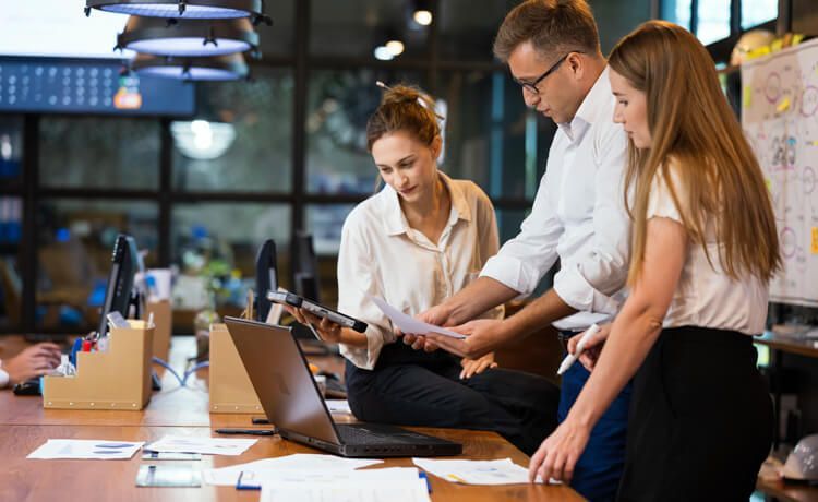 Drei Menschen diskutieren am Schreibtisch. Drei Menschen diskutieren am Schreibtisch.