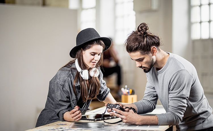 Junge Studenten gucken auf eine Kamera.