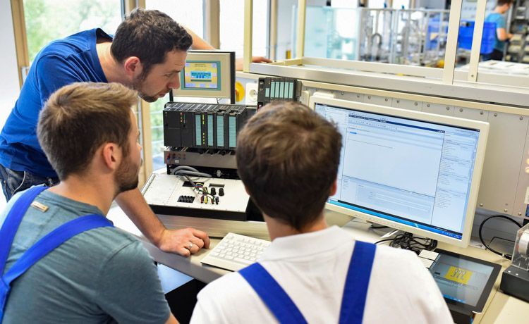 Drei junge Männer bei der Arbeit als Elektroanlagenmonteur.