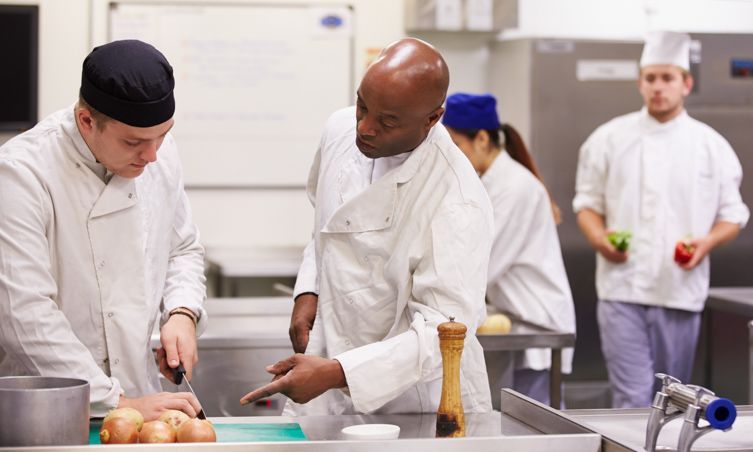 Azubi mit Ausbilder in der Küche