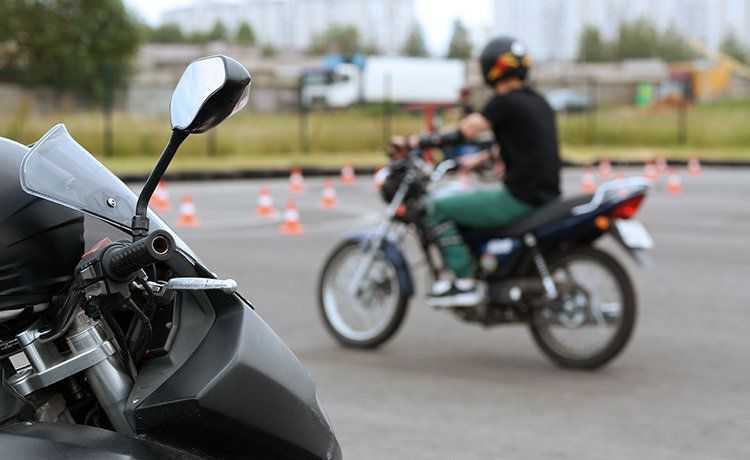 Junger Mann übt Motorradfahren auf einem Übungsplatz.